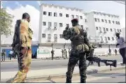  ??  ?? Somali government soldiers take positions outside the Maka Al-Mukarama hotel after an attack by al Shabab militants in Mogadishu on Saturday.