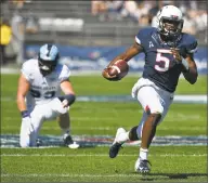  ?? Jessica Hill / Associated Press ?? UConn quarterbac­k David Pindell ( 5) breaks away from Rhode Island defensive lineman Brandon Ginnetti ( 99) for a touchdown on Saturday.