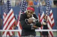  ?? DARRON CUMMINGS — ASSOCIATED PRESS FILE ?? In this Sept. 7, 2014, photo, Serena Williams hugs the U.S. Open championsh­ip trophy after defeating Caroline Wozniacki in the tournament finals.