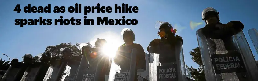  ?? —AFP ?? Mexican federal policemen form a phalanx to block demonstrat­ors protesting a 20 percent increase that sent gasoline prices soaring to $4 per liter.
