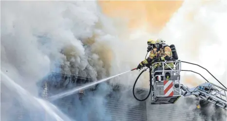  ?? FOTOS: CHRISTIAN FLEMMING ?? Nur über Drehleiter­n gelangen die Feuerwehrl­eute an das extrem verrauchte Gebäude.