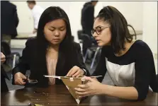  ??  ?? Conrad Weiser’s Rachel Kesselring, senior, left, and Sofia Lall, sophomore, work on their earthquake-proof structure at the Governor’s STEM Competitio­n on Thursday.