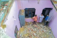  ?? PTI PHOTO ?? Residents of a house, the roof of which collapsed in Wednesday night's storm, look on at Vaishno Colony in Agra on Thursday.
