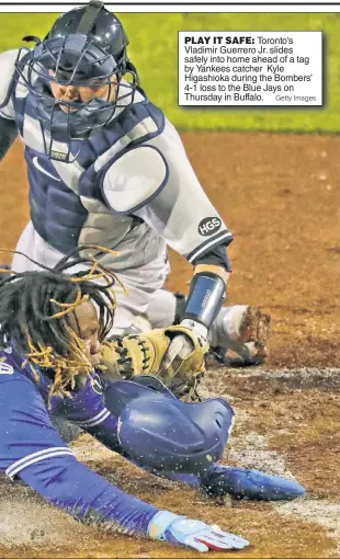  ??  ?? PLAY IT SAFE: Toronto’s Vladimir Guerrero Jr. slides safely into home ahead of a tag by Yankees catcher Kyle Higashioka during the Bombers’ 4-1 loss to the Blue Jays on Thursday in Buffalo.