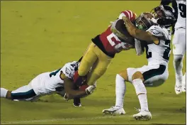  ?? TONY AVELAR — THE ASSOCIATED PRESS ?? San Francisco 49ers running back Jerick McKinnon (28) runs for a touchdown between Philadelph­ia Eagles cornerback Darius Slay, left, and Marcus Epps during the second half in Santa Clara on Sunday, Oct. 4.