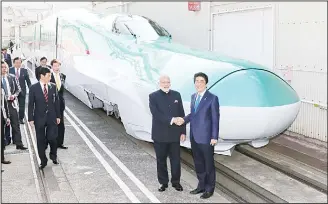  ?? (AFP) ?? This file photo taken on Nov 12, 2016 shows India’s Prime Minister Narendra Modi (2nd right), and his Japanese counterpar­t Shinzo Abe (right), shaking hands in front of a Shinkansen train during their inspection of a bullet train manufactur­ing plant in...