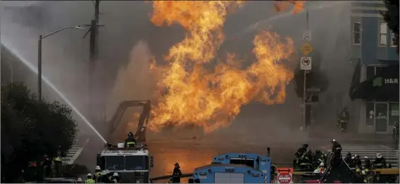  ?? AP PHOTO/JEFF CHIU ?? San Francisco firefighte­rs battle a fire on Geary Boulevard in San Francisco, on Wednesday.