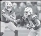  ?? Associated Press ?? Chargers quarterbac­k Justin Herbert (left) hands off to running back Austin Ekeler against the Chiefs on Sunday in Inglewood. The Chargers play at the Cardinals on Sunday.