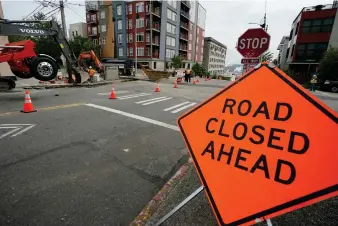  ?? (AP Photo/Ted S. Warren) ?? A sign is shown near ongoing work on a project to replace water main pipes, Wednesday, June 15, 2022, in downtown Tacoma, Wash. Inflation is taking a toll on infrastruc­ture projects across the U.S., driving up costs so much that state and local officials are postponing projects, scaling back others and reprioriti­zing their needs.