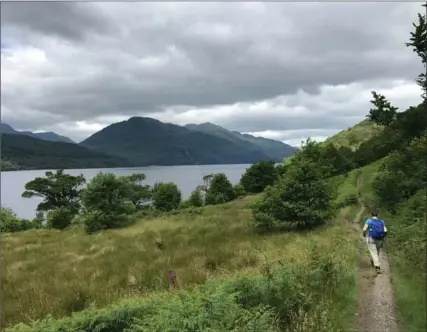  ??  ?? A hiker on the shore of Loch Lomond, walking Scotland’s oldest long distance path, the West Highland Way. Loch Lomond is part of the Trossachs National Park and is Britain’s largest body of inland water at 35 kilometres long.