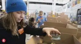  ?? BERNARD WEIL/TORONTO STAR ?? Reese Mencke, 10, a Grade 5 student from Blythwood Elementary School, places the can of tuna in a box with other canned seafood at the Daily Bread Food Bank in Etobicoke.