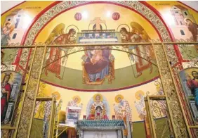  ??  ?? The upper portion of the iconograph­y was begun in 1979 by Alias Katsaros. The lower portion of the wall in the altar is being completed by Mother Theodora Balaban.