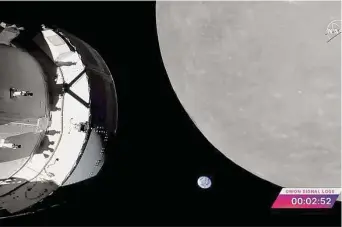 ?? NASA TV ?? NASA’s Orion capsule (left) nears the moon, right, with the Earth in the center. The close approach of 81 miles is the first time a capsule has visited the moon in 50 years.