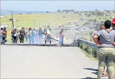  ?? Picture: SIBONGILE NGALWA ?? TAKING A STAND: Nxarhuni villagers barricade the street to prevent both taxi and bus drivers from entering