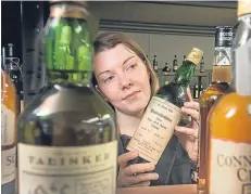  ?? Picture: Paul Reid. ?? Auction assistant Lisa Turberfiel­d with the vintage whisky which was sold for a combined total of £4,000 on Saturday.