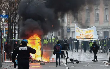  ?? — AFP ?? Fiery message: ‘ Yellow vests’ clashing with French Gendarmes during an anti-government demonstrat­ion in Strasbourg, eastern France.