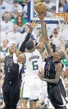  ?? Rick Bowmer Associated Press ?? JOE JOHNSON, shooting over Marreese Speights and Jamal Crawford, lifted the Jazz with 28 points, 13 in fourth quarter.