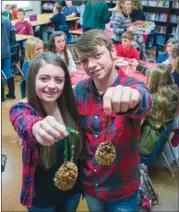 ??  ?? Madison Hughes, left, and Hunter Pruitt, students at Bethel Middle School in Bryant, show the pinecone birdseed Christmas ornaments that members of the Bethel Habitat Youth United club made during a meeting in November. The ornaments were later sold at...