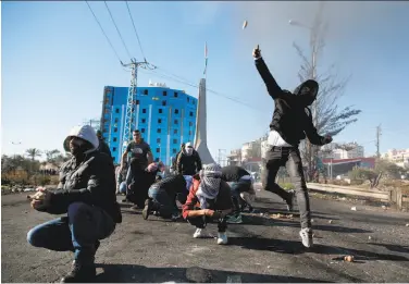  ?? Abbas Momani / AFP / Getty Images ?? Palestinia­n protesters clash with Israeli troops in the West Bank city of Ramallah following calls for protests against President Trump’s recognitio­n of Jerusalem as Israel’s capital.