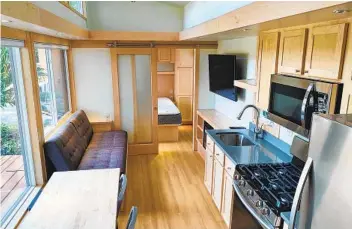  ??  ?? The kitchen in this tiny house is small, but it’s equipped with full-size appliances.