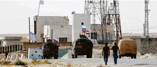  ?? Omar Sanadiki/Reuters ?? Bandeiras da Rússia e da Síria sobre veículos militares que circulam próximo a Manbij, cidade curda ocupada por sírios