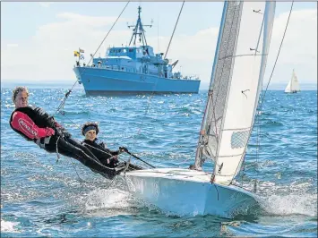  ?? Picture: CHRISTOPHE FAVREAU ?? FINE TUNING: Dudley Isaacs and Sigi Bailes will compete in the 505 World Championsh­ips in black vests in honour of two friends who died. In the background is the event committee’s boat, an SA Navy minesweepe­r