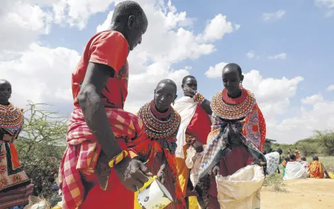  ?? ?? Women from the Samburu tribe receive a food donation given due to an ongoing drought, in the town of Oldonyiro, Isiolo county, Kenya, Oct. 8, 2021.