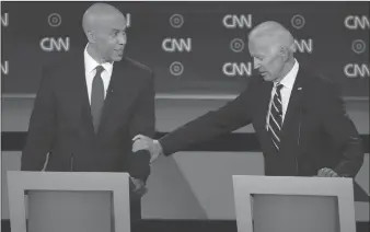  ?? Getty Images/tns ?? Democratic presidenti­al candidate Sen. Cory Booker (D-N.J.), left, and former Vice President Joe Biden speak during the Democratic Presidenti­al Debate at the Fox Theatre in Detroit on Wednesday.