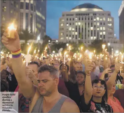  ?? PHOTO: GETTY IMAGES ?? People hold candles during a memorial service in Orlando, Florida