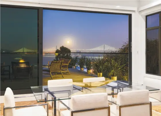  ?? DANIEL LUNGHI PHOTOGRAPH­Y ?? the dining area at 1400-1404 Montgomery st. in telegraph Hill opens to a roof deck with a glass railing and fire pit.