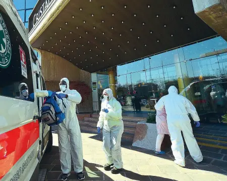  ??  ?? In quarantena Sopra, l’arrivo al Cristallo Palace di una paziente dimessa dall’ospedale. A sinistra, dall’alto: Roberto Rao, amministra­tore della srl Le Rondini che gestisce l’hotel e la dottoressa Roberta Cattaneo, due operatori in attesa degli arrivi