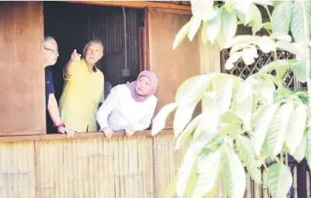  ??  ?? (From right) Nancy and Ting look out from the window of a bamboo house at Libiki Bamboo Resort.