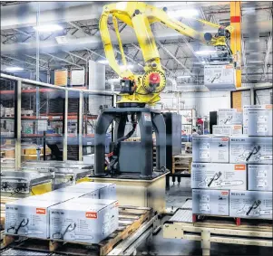  ?? JOHN MINCHILLO/THE CANADIAN PRESS/AP ?? In this May 25 photo, a giant robotic arm loads pallets full of chainsaws prepared for shipping at the Stihl Inc. production plant in Virginia Beach, Va. A new report by Deloitte suggests government­s and industries are not doing enough to keep up with...