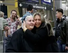  ?? AP PHOTO ?? Nadia Hanan Madalo (center right) hugs her mother, Alyshooa Kannah (left) at the airport after arriving from Iraq on Wednesday in San Diego.