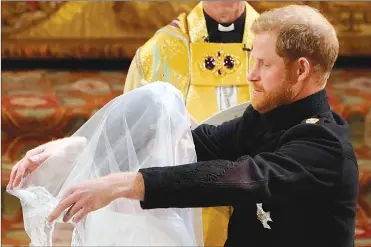  ?? Associated Press photo ?? Britain’s Prince Harry removes the veil of Meghan Markle during their wedding ceremony at St. George’s Chapel in Windsor Castle in Windsor, near London, England, Saturday.