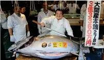  ??  ?? Kiyoshi Kimura — who topped the previous auction record of ¥155 million he himself set in 2013 — preparing to cut his prized 278kg bluefin tuna at his restaurant in Tokyo on Saturday. —