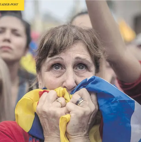  ?? SANTI PALACIOS / THE ASSOCIATED PRESS ?? People watch the voting process on a large screen Friday during a rally outside the Catalan parliament in Barcelona. Catalonia’s regional parliament passed a motion saying they are establishi­ng an independen­t Catalan republic.