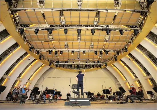  ?? Al Seib Los Angeles Times ?? THE LOS ANGELES Philharmon­ic, conducted by Gustavo Dudamel, rehearses at the Hollywood Bowl for Saturday’s special performanc­e for essential workers.