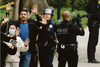  ?? Chip Somodevill­a / Getty Images ?? Police provide cover Friday as residents are told to run with their hands up while being evacuated from their homes after a gunman opened fire in the Van Ness area of Washington.