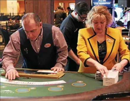  ?? CHARLES PRITCHARD — ONEIDA DAILY DISPATCH ?? Black Jack Dealer Guy Basil and Floor Supervisor Cathy McGrath inspect cards for any defects on Thursday March 1, 2018.