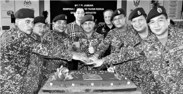 ??  ?? Fadzil (centre) and others jointly cutting the anniversar­y cake, as Khiu (behind Fadzil) and Saiful (fourth right) look on.