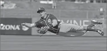  ?? Associated Press ?? Diving throw: San Diego Padres' Gordon Beckham makes a throw on a ball hit by Los Angeles Angels' Mike Trout during the first inning of a spring training baseball game in Tempe, Ariz., in this Thursday, Feb. 27, 2020, file photo.