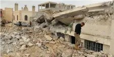  ??  ?? People inspect a damaged mosque after an airstrike on the rebel-held village of al-Jina
