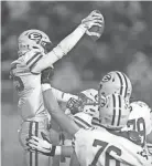  ?? WHITLOCK/MASSILLON INDEPENDEN­T KEVIN ?? Danny Enovitch's teammates lift him up to celebrate a Lakewood St. Edward touchdown on Friday.