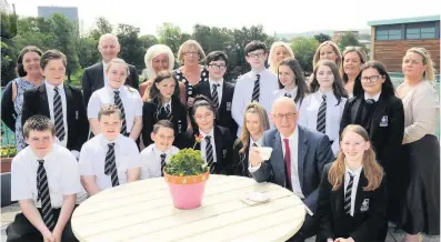  ??  ?? Enjoying the sun The Deputy First Minister with pupils and staff in the Kickstart Garden 310518holy­cross_04