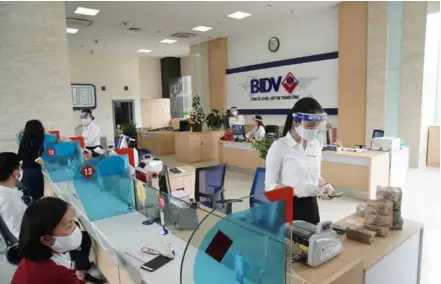 ?? Photo courtesy of the bank ?? Customers at a branch of Bank for Investment and Developmen­t of Việt Nam (BID) in Hà Nội. The Government’s interest rate incentive package can help reduce the average lending interest rate by 20-40 basis points in 2022.