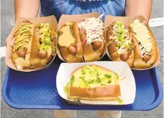  ?? COURTESY UMAMI DOGS ?? Umami Dogs’ loaded-up dogs are made with grass-fed all-beef franks, split-top New England rolls and a whole lot of toppings.