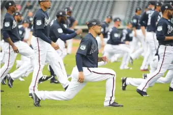  ?? ASSOCIATED PRESS PHOTOS ?? Atlanta Braves infielder and outfielder Jace Peterson, center, stretches Saturday with teammates during the first full-squad spring training workout at Lake Buena Vista, Fla.