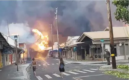  ?? ALAN DICKAR VIA AP ?? Smoke and flames engulf Front Street in Lahaina on Maui, Hawaii, on Tuesday as a deadly wildfire tears through the island. Aerial video of Lahaina shows dozens of homes and businesses destroyed in the historic town center, a popular tourist area.