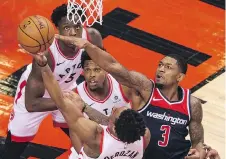 ??  ?? Kyle Lowry, centre, and OG Anunoby, left, look on as DeMar DeRozan tries to get the ball past Washington’s Bradley Beal during Toronto’s 130-119 win at the Air Canada Centre in Toronto on Tuesday night.